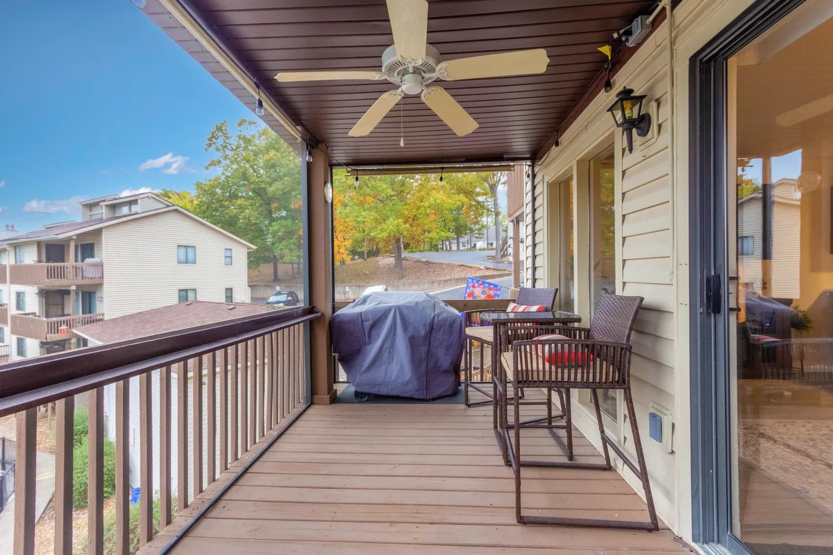 This image shows a cozy balcony furnished with comfortable outdoor seating, a grill, and surrounded by beautiful fall foliage. The setting offers a sweeping view of the lake and creates a private, picturesque spot for romantic evenings or a morning coffee together while soaking in the seasonal colors.